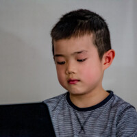 male kid learning piano