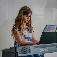 female kid playing piano