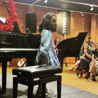 female kid on the piano performing