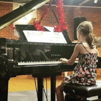 female kid playing piano