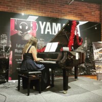 girl in black playing piano