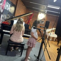 lady playing piano and girl singing